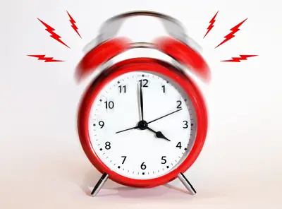 Ringing alarm clock representing a loud phone siren
