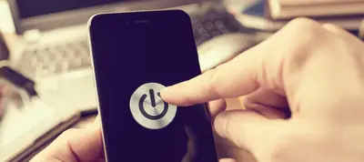 Finger pressing the power icon on a phone screen